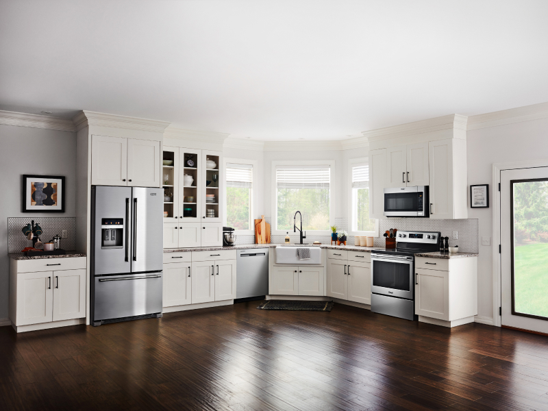 Open kitchen with white cabinetry and stainless steel French door refrigerator