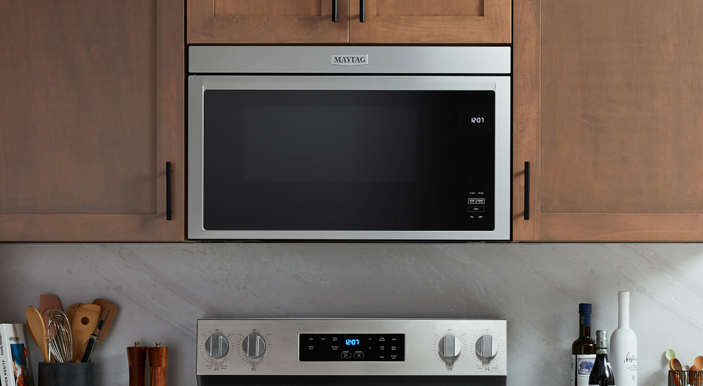 An over-the-range microwave set in light brown cabinetry