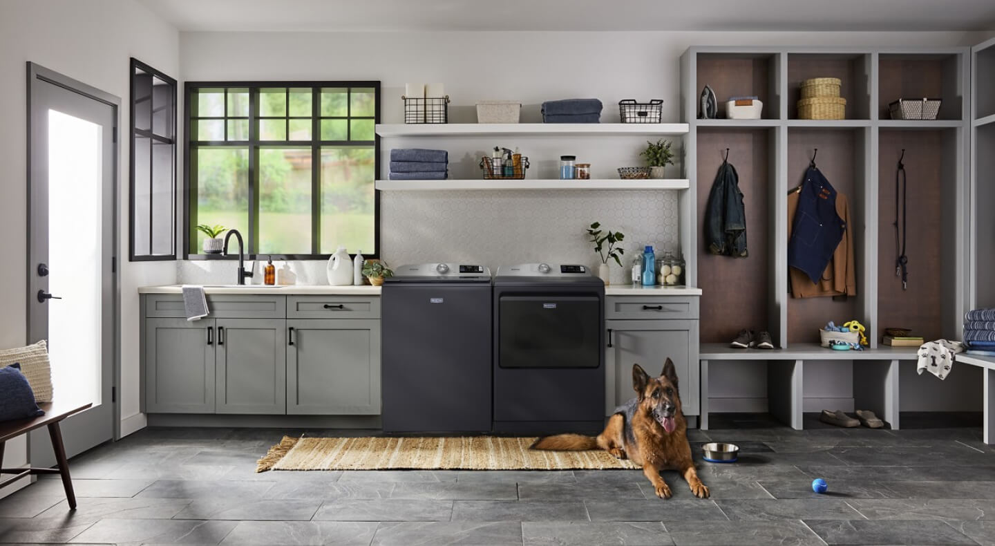 Maytag® washer and dryer set in a mudroom with grey cabinets
