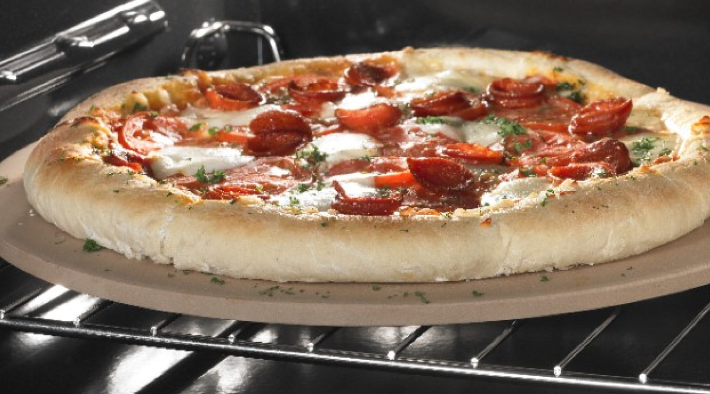 A pepperoni pizza baking in an oven.