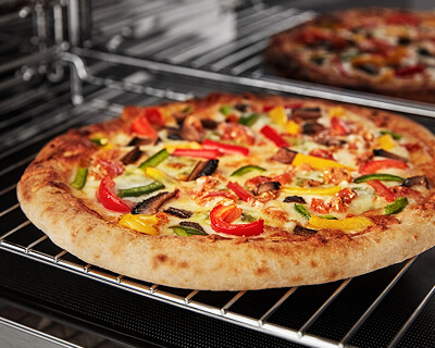 Pizza baking on a rack in a microwave cavity 