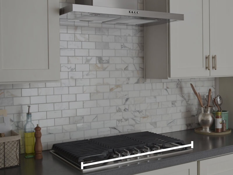 Range hood over cooktop with marks showing how to measure horizontally