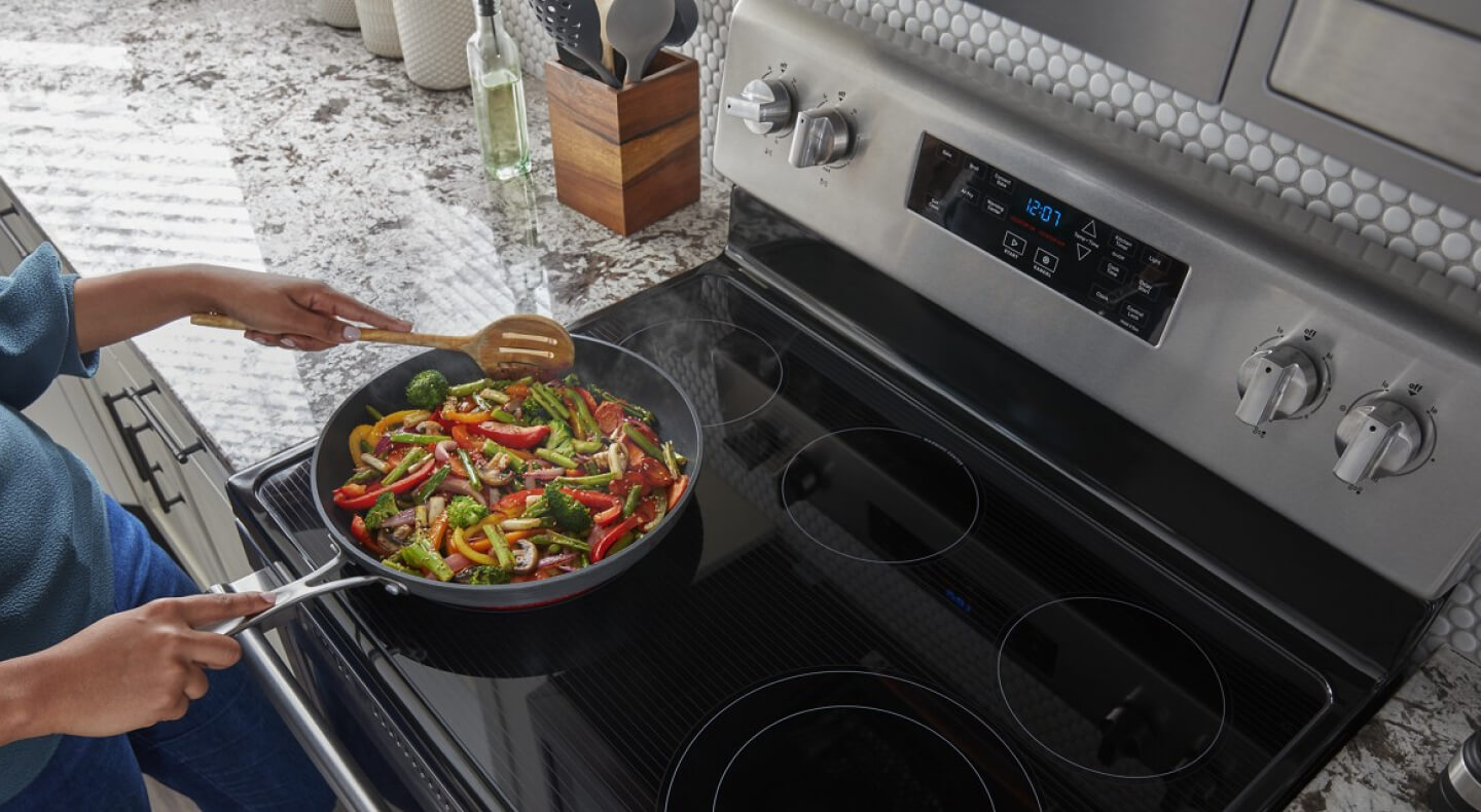 Person making stir-fry on an electric stovetop
