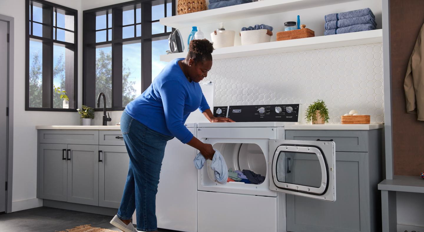 Person loading laundry into a commercial-grade dryer