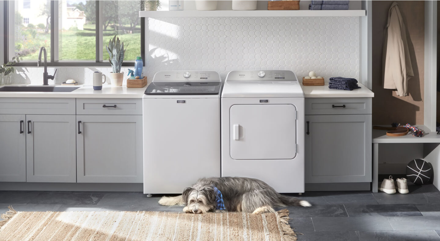 Maytag® top load washer and dryer in a modern white laundry room