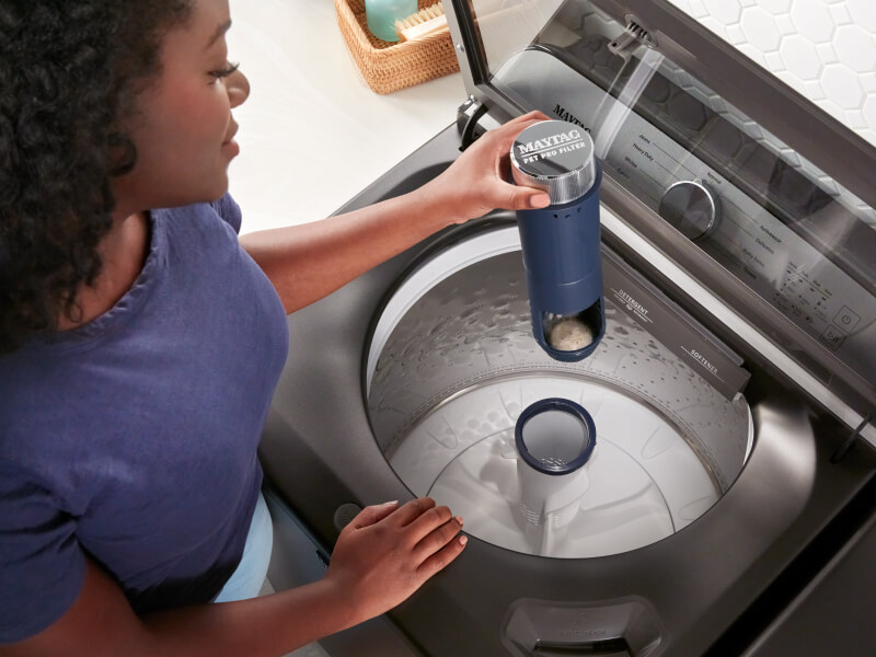 Person removing a Maytag® agitator from a top load washer