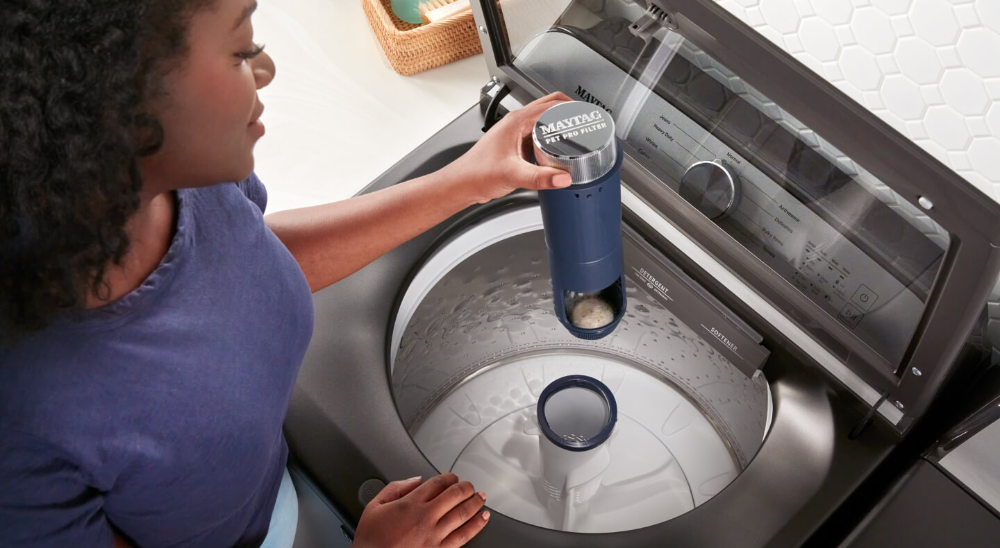 Person removing a Maytag® agitator from a top load washer
