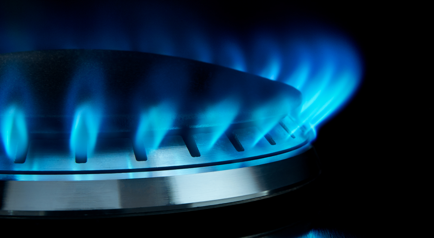 Close-up of blue flames on gas stovetop burners