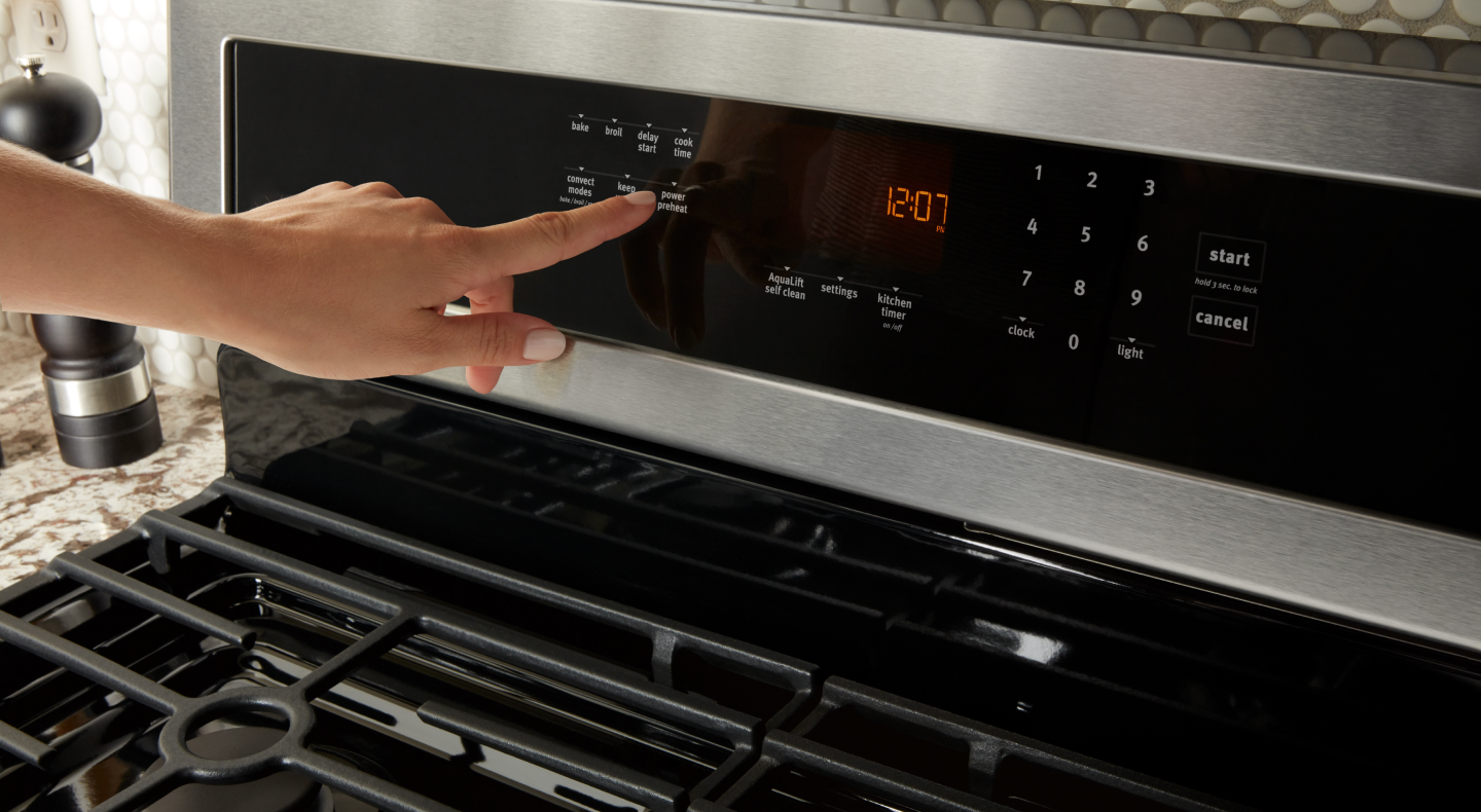 Person selecting a bake setting on a dual fuel range