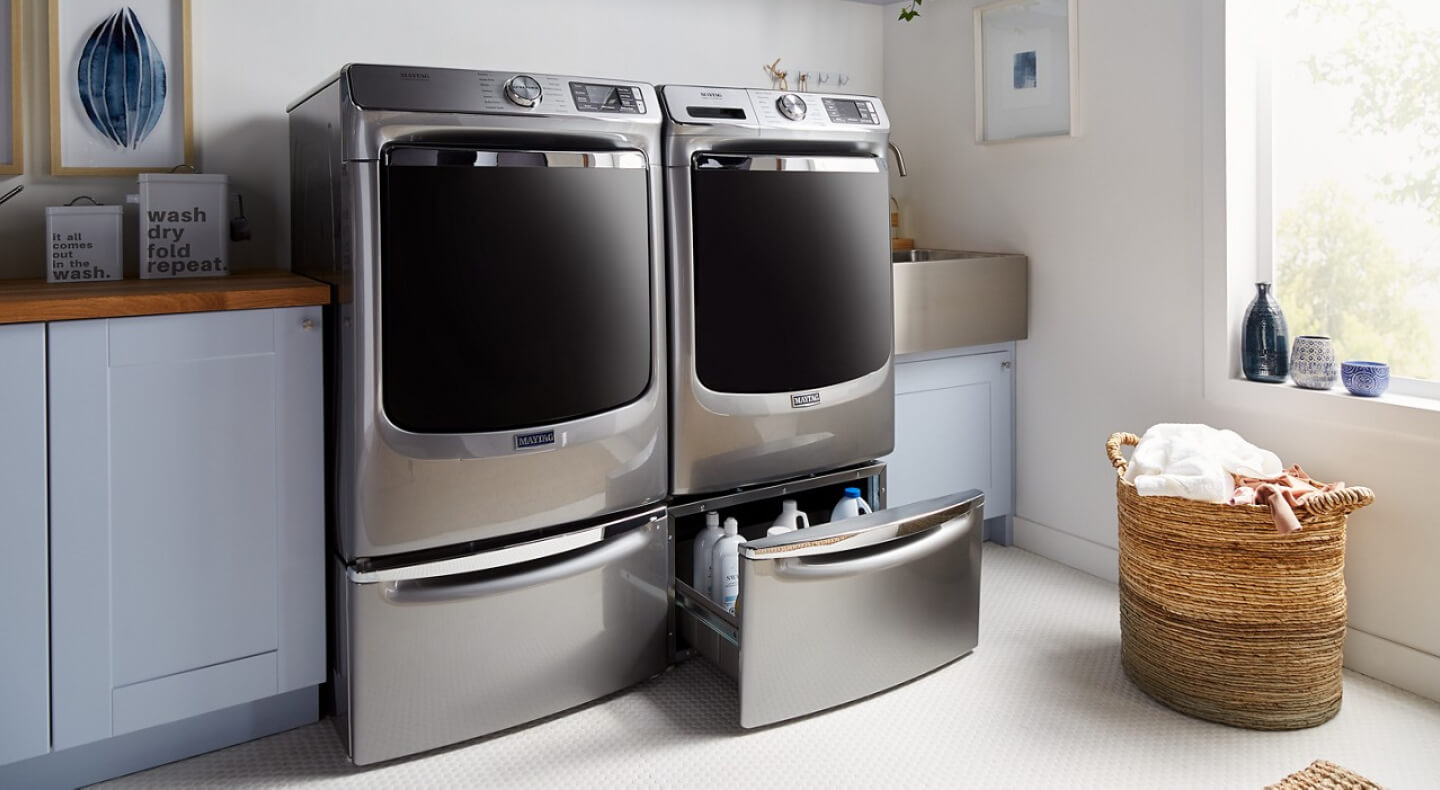 Maytag® front load laundry pair on pedestals with one pedestal drawer open