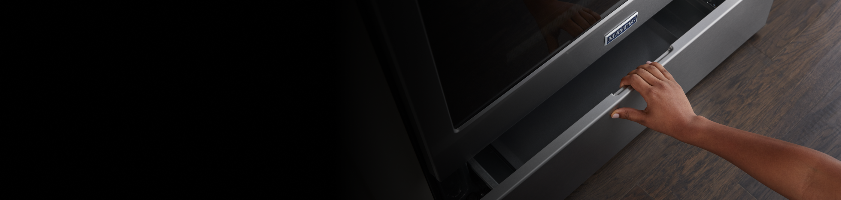 A person pulling open a Maytag® oven drawer
