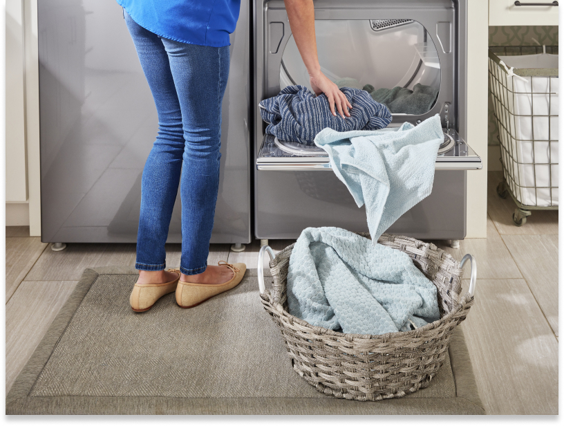 Person unloading clothes from the dryer into a laundry basket