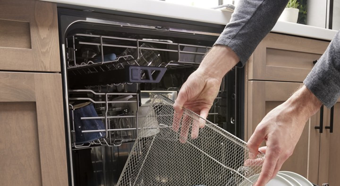 A person pulling an air fry basket out of a Maytag® dishwasher