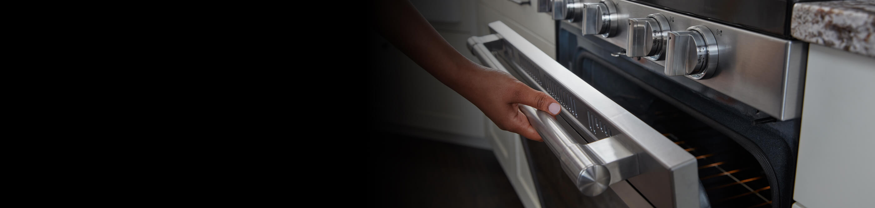Person cracking open the door of a gas oven