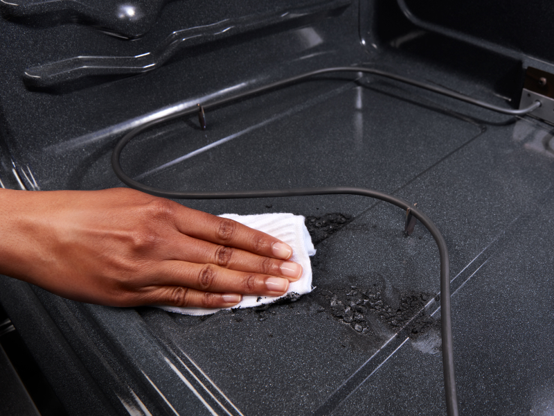 Person cleaning inside of oven
