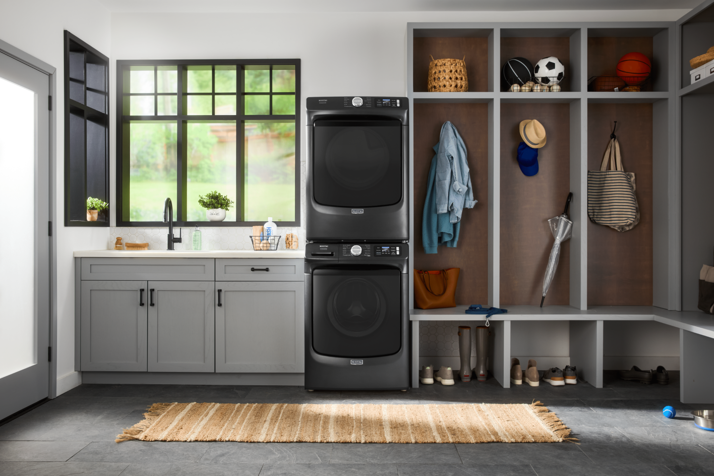 Stainless appliances in a kitchen with medium wood cabinets with black hardware