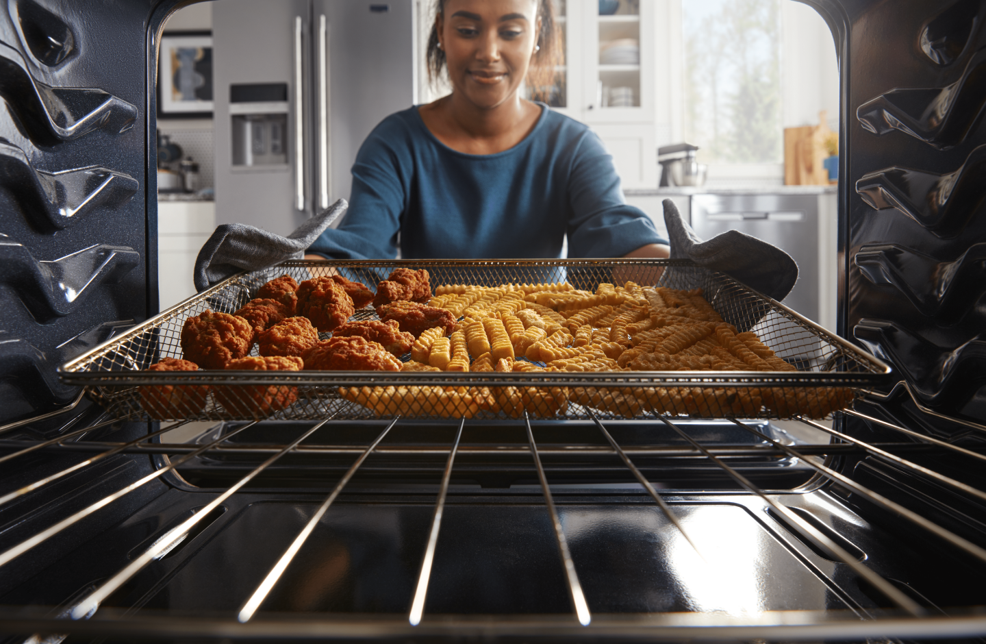 Woman pulling food out of an oven cavity