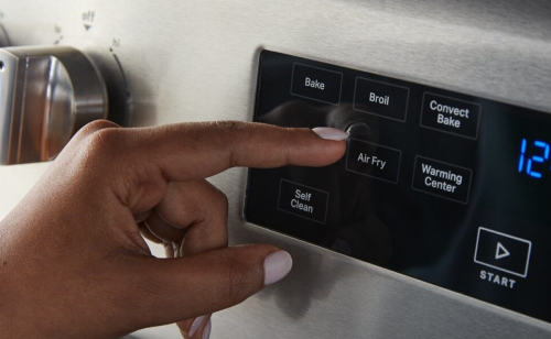 Person selecting the air fry button on a range