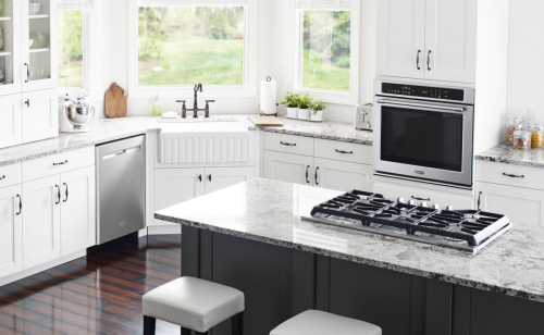 Interior overview of kitchen with gas range and wall oven.