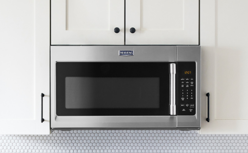 Stainless steel Maytag® over-the-range microwave and range in a bright kitchen