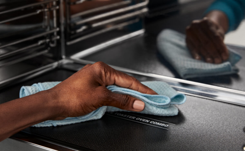 Person cleaning the inside of a Maytag® microwave