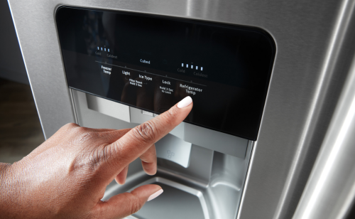 Person pressing a button on a refrigerator