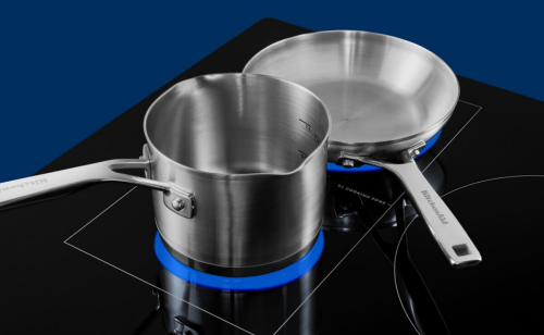 Stainless steel cookware warming on induction cooktop heating elements