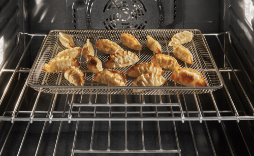 Several potstickers in a basket inside an oven