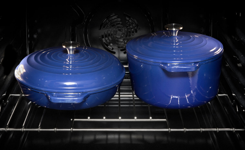 Two covered blue ceramic pots on an oven rack