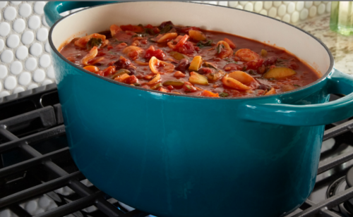 A dish of food simmering on a gas stovetop