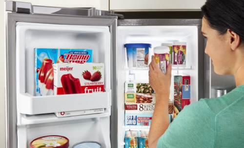 Woman standing in front of an open freezer