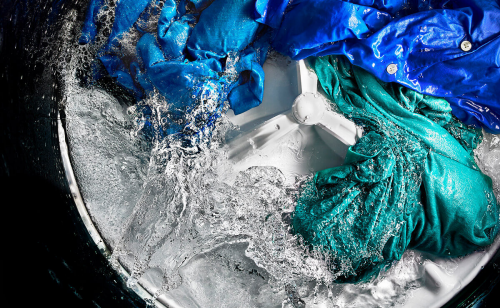 Overhead view of clothes agitating in a top load washer
