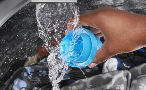 Hand rinsing detergent cup under running water