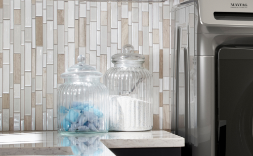 Glass containers filled with laundry pods and powdered detergent
