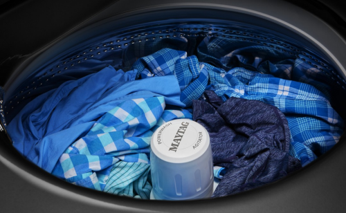 Close-up of blue clothes inside a Maytag® top load washer