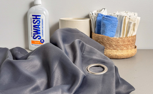 Curtain fabric on a table with cleaning supplies