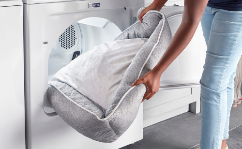 A person holding a dog bed