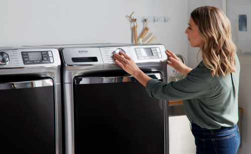 Person adjusting Maytag® dryer settings