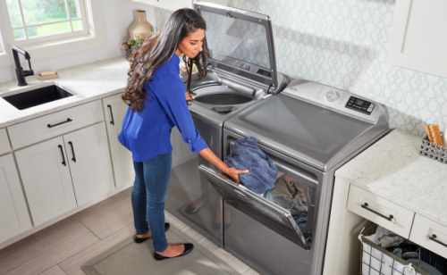 Person at open washer and dryer