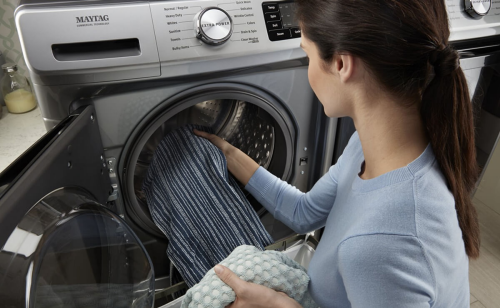 Image of person taking clothing out of a washer