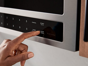 Person selecting settings on a microwave