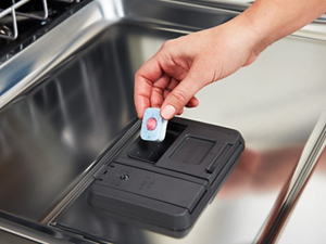 Dishwasher detergent being added to dispenser