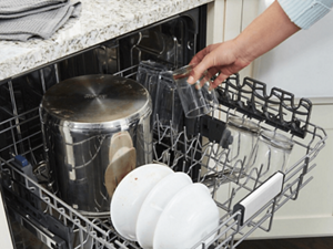  Person putting glasses on top rack of dishwasher