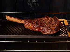 Grilling a steak inside a Maytag® range