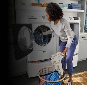 Person loading laundry into a front load washing machine