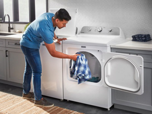 A person pulling a shirt out of the dryer