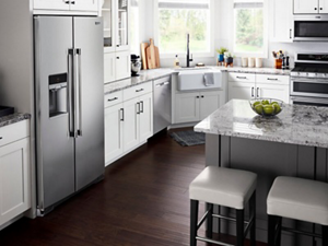 Counter-depth side-by-side refrigerator in kitchen with white cabinets
