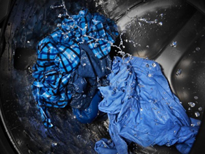 Blue clothing being cleaned in a washing machine