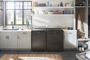 A pair of Maytag® washers and dryers in a white laundry room